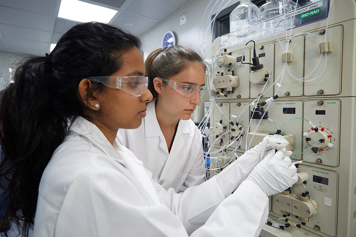 Two scientists handling lab equipment