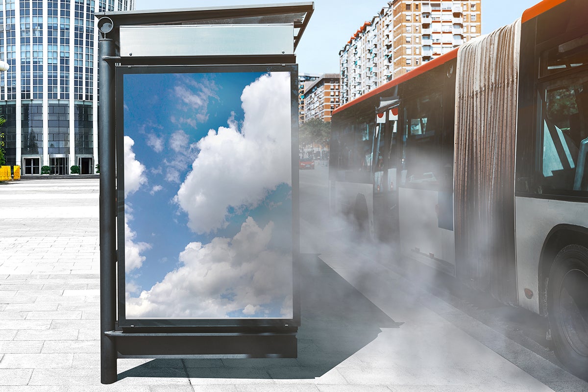 Digital signage at a bus stop in a cloud of pollution from traffic.