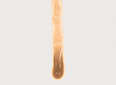 Close-up of a brown liquid clinging to the surface of a competitor’s membrane. The liquid does not roll-off and clogs the membrane leading to reduced airflow.