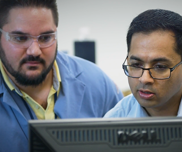 Two men looking at a computer screen