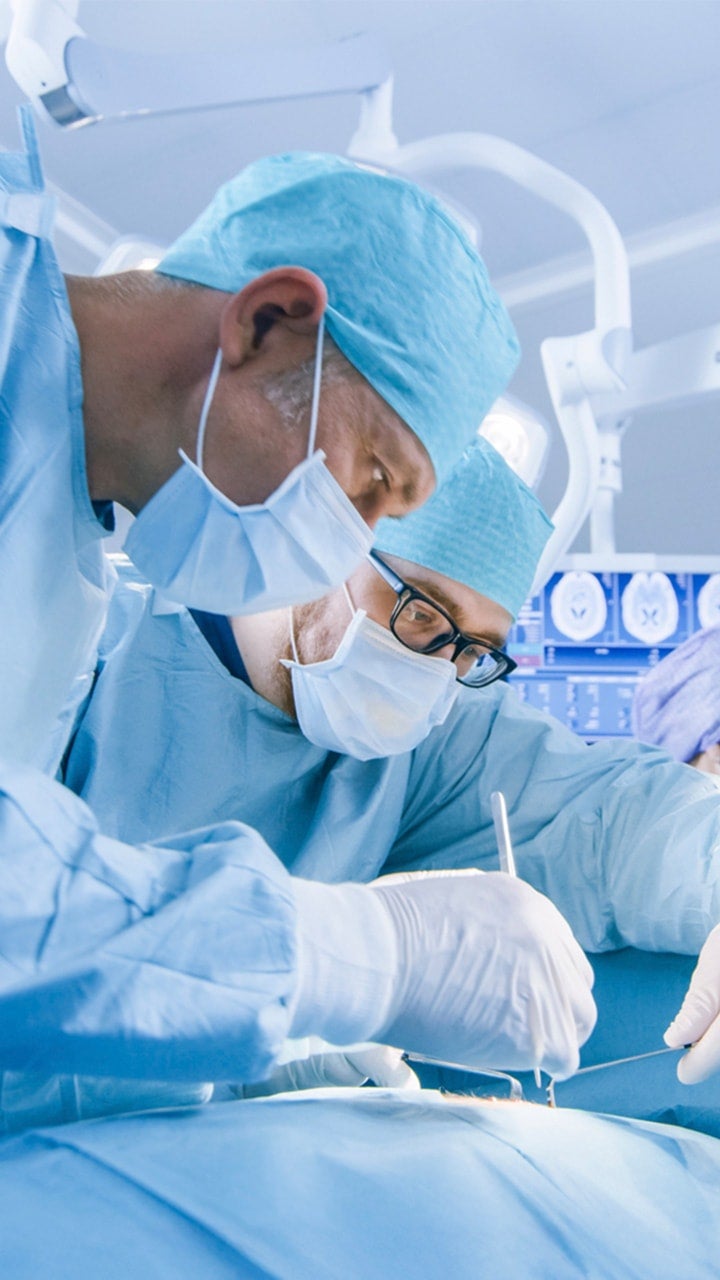 Two surgeons examining a patient.