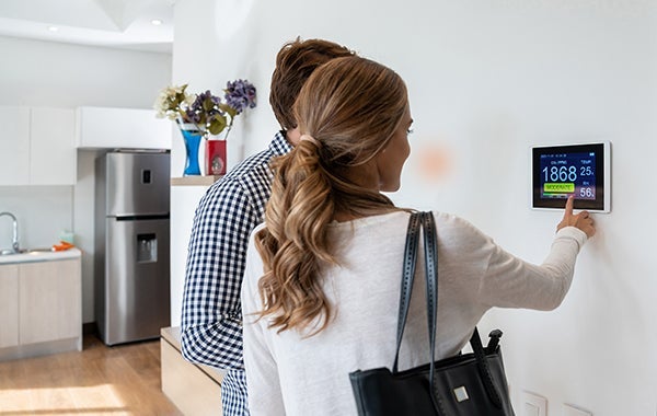 Image of man and woman using digital thermostat from Infineon case study