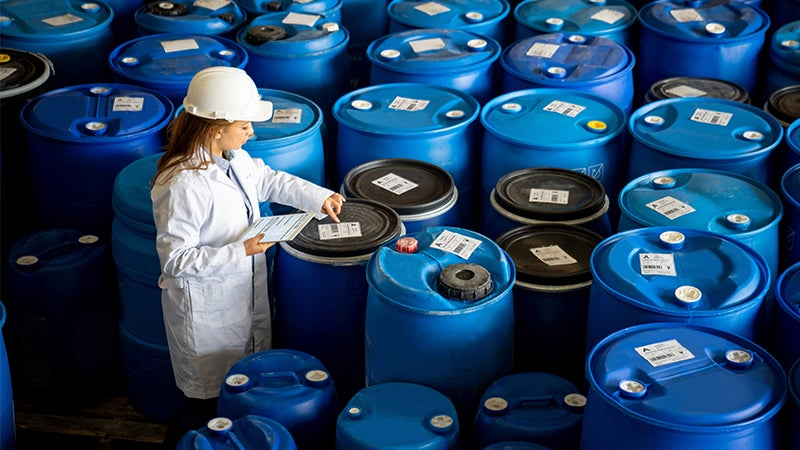 Foreperson doing quality control on a stock of chemical barrels
