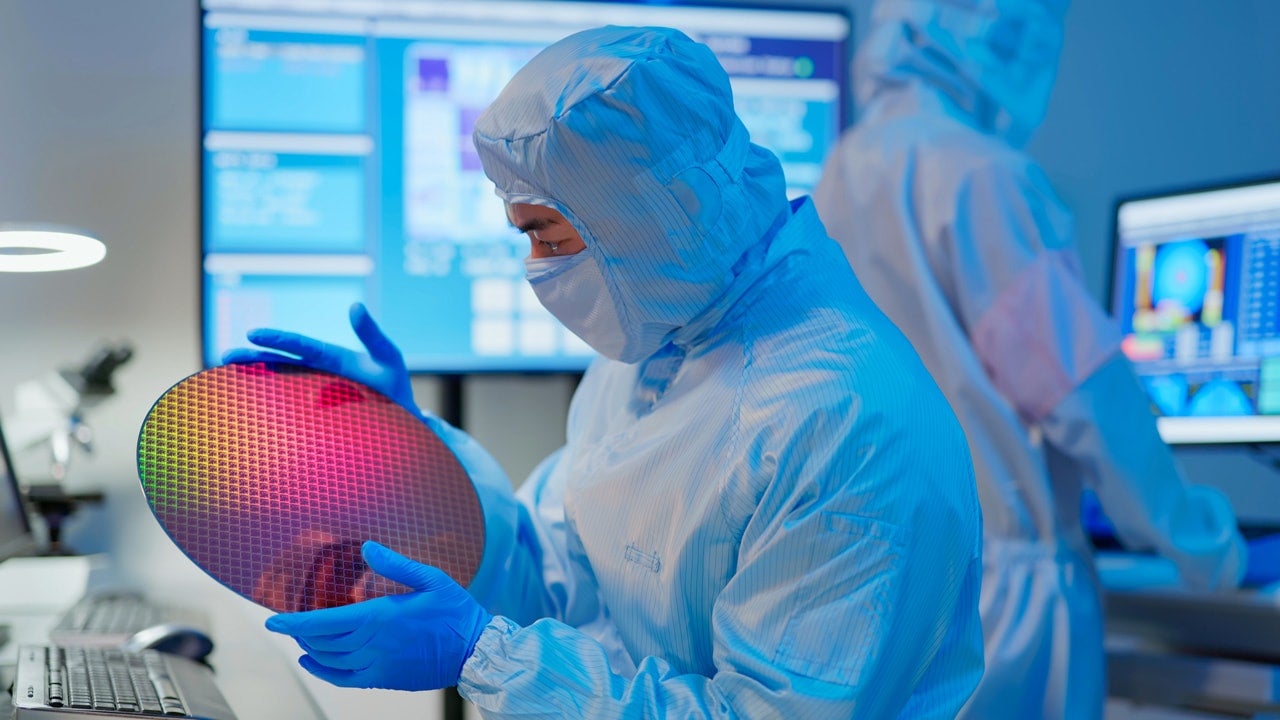 Technician using PPE in a clean environment.