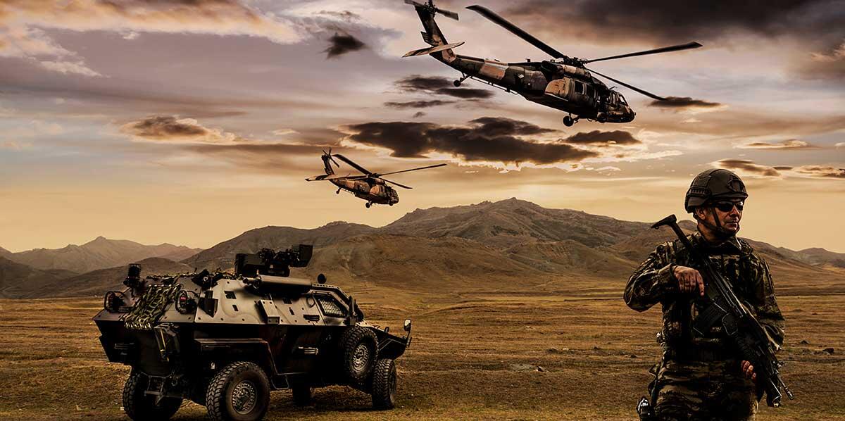 Soldier near military vehicle and helicopters