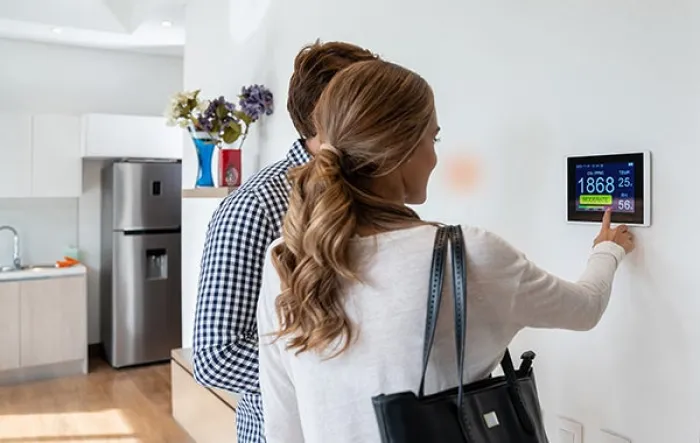 Image of man and woman using digital thermostat from Infineon case study