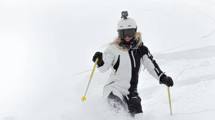 woman skiing with camera mounted to her helmet