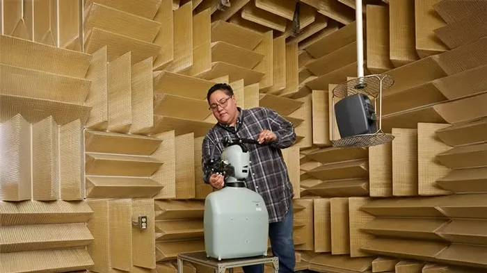 Man using a device to record in a sound-proof room.
