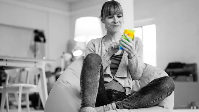 Woman sitting in chair looking at smart phone