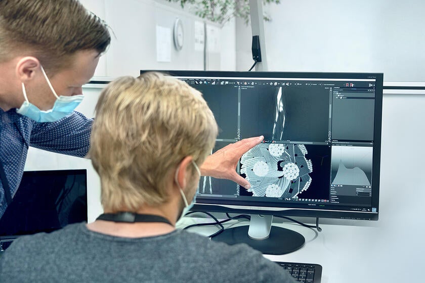 Engineers discuss their findings while reviewing detailed layer-by-layer CT scans of a Gore Lithography Cable. 