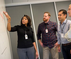 Associates problem solving around a white board