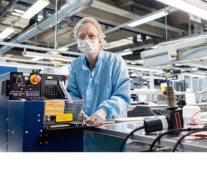 An Associate working on a machine in production.