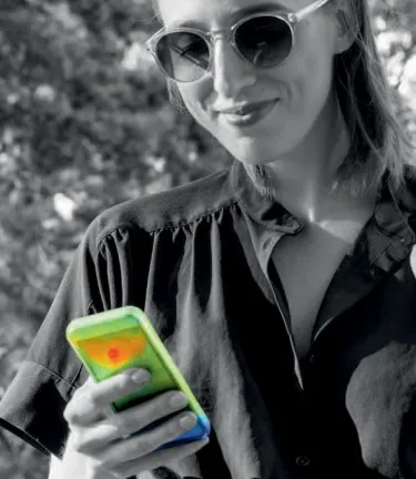 Woman looking at her mobile phone while eating an ice cream cone