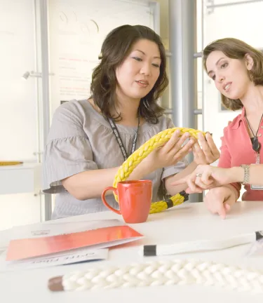two female associates inspectaing fiber materials
