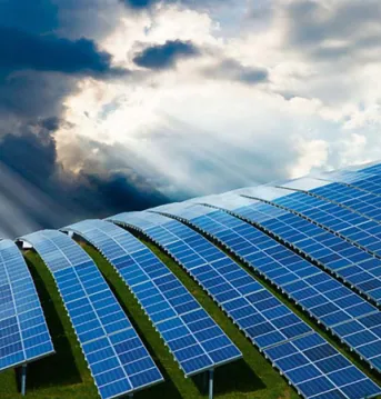 Sun shining on a field with rows of Solar Panels.