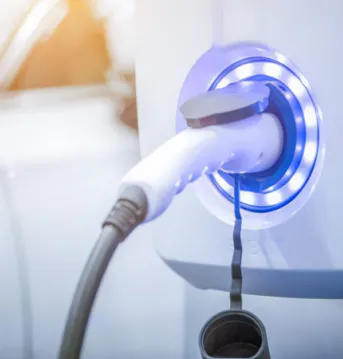 A closeup of an EV charging port attached to a charger cable.