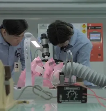 Two people in manufacturing and testing setting