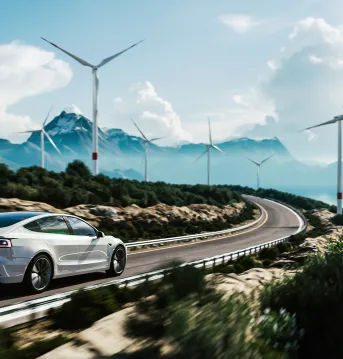 Car driving on highway lined with wind turbines