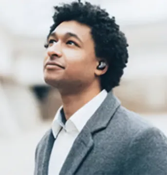 Man wearing earbuds looking up.