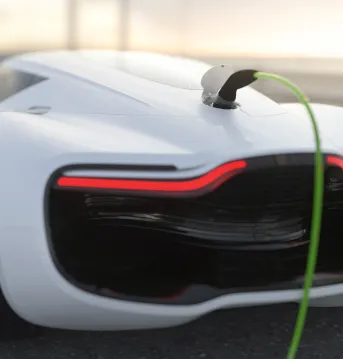 Modern generic electric white sports car at sunrise charging before a race