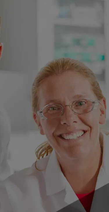 Two workers smiling while wearing PPE.