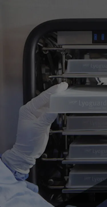 Worker placing GORE® LYOGUARD® Freeze-Drying Trays in a Freeze Dryer