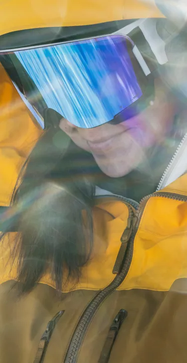 woman wearing yellow gore-tex jacket out in the snow