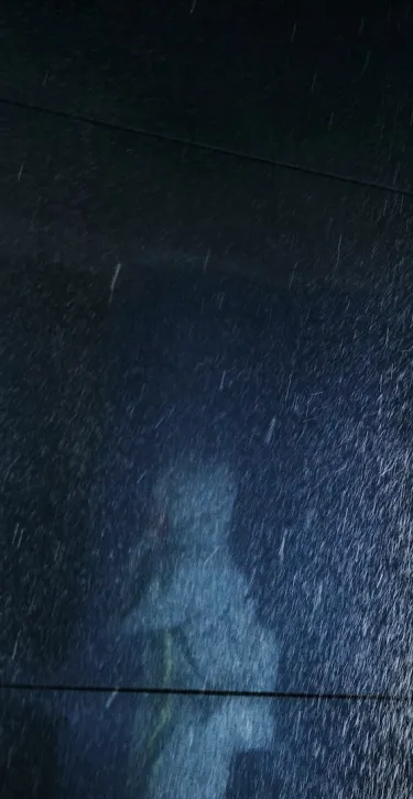 man in raincoat standing in the rain testing room