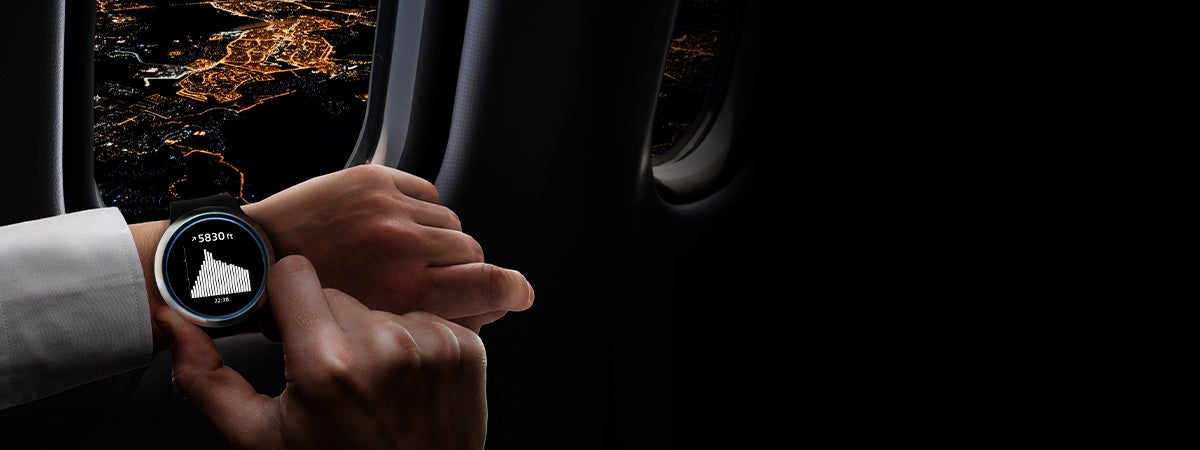 Hands of someone looking at a wearable device on a plane